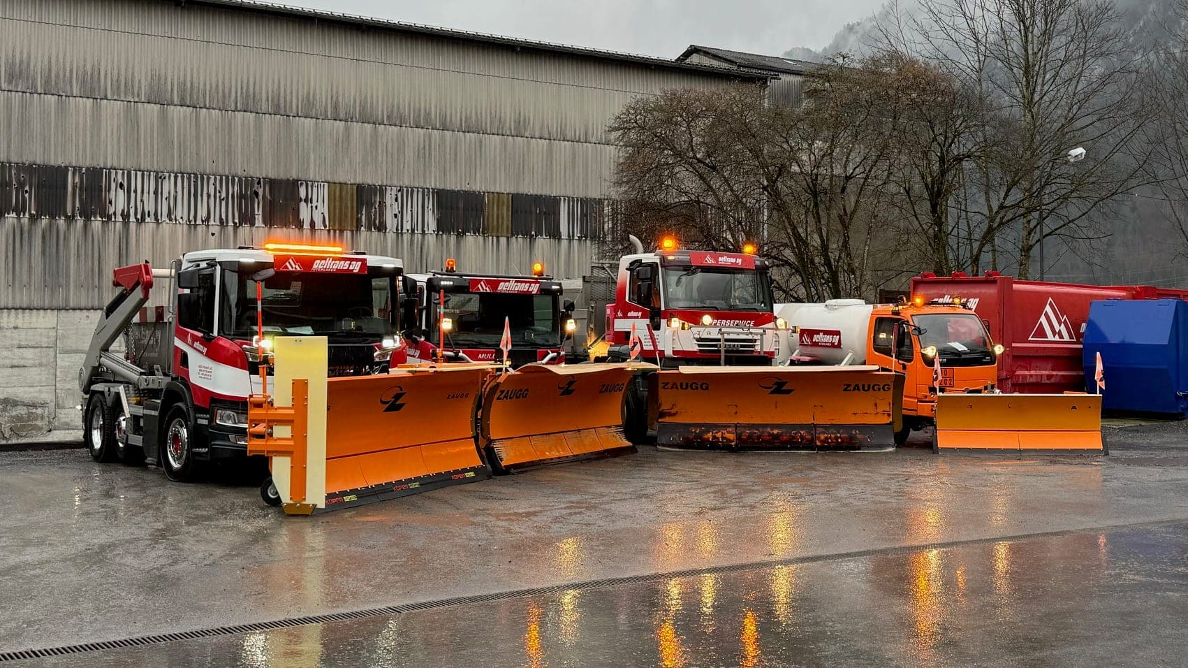 oeltrans Fahrzeuge mit orangen Schneepflügen vor der Halle